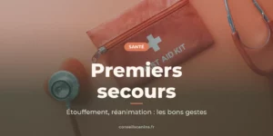 Trousse de premiers secours rouge et stéthoscope posés sur un fond rose